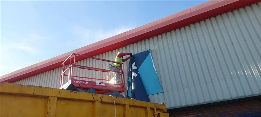 Signage removal from a scissor lift at the Rylands project