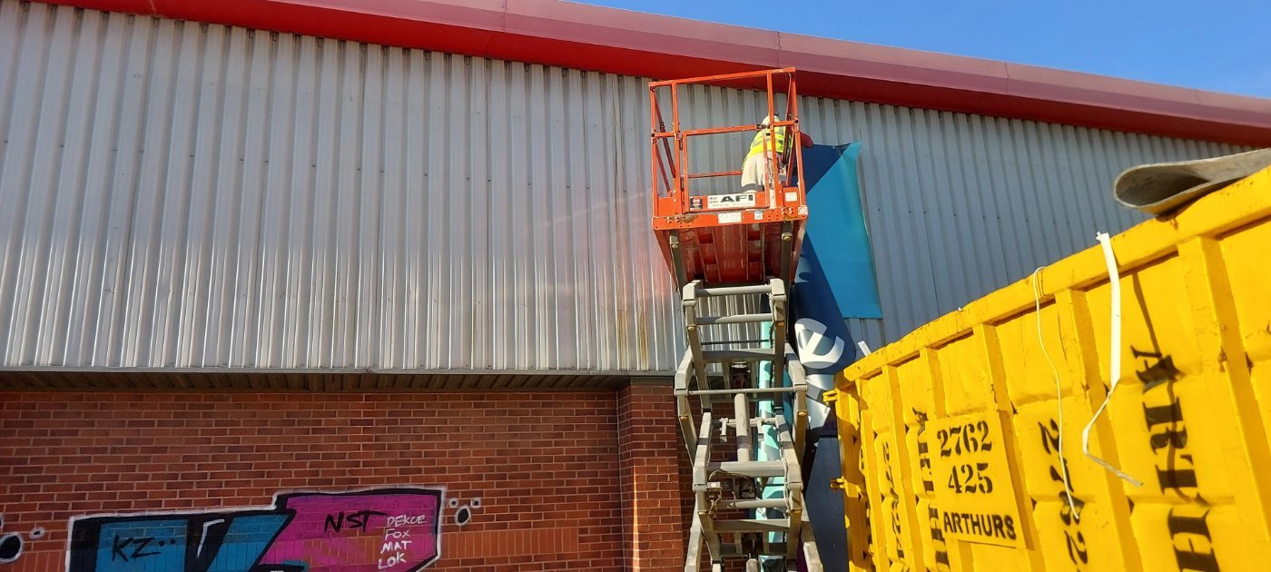 Cladding removal works from a scissor lift at the Rylands project