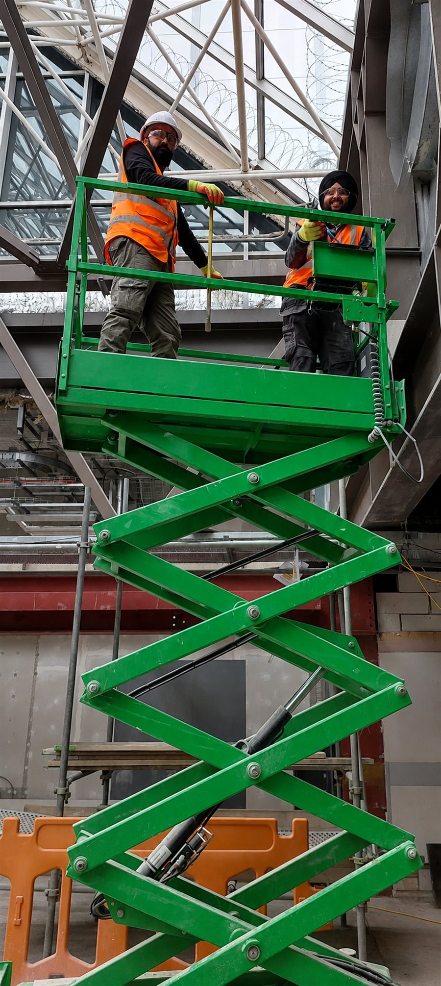 Scissor lift works beneath the atrium roof at the Torkington project